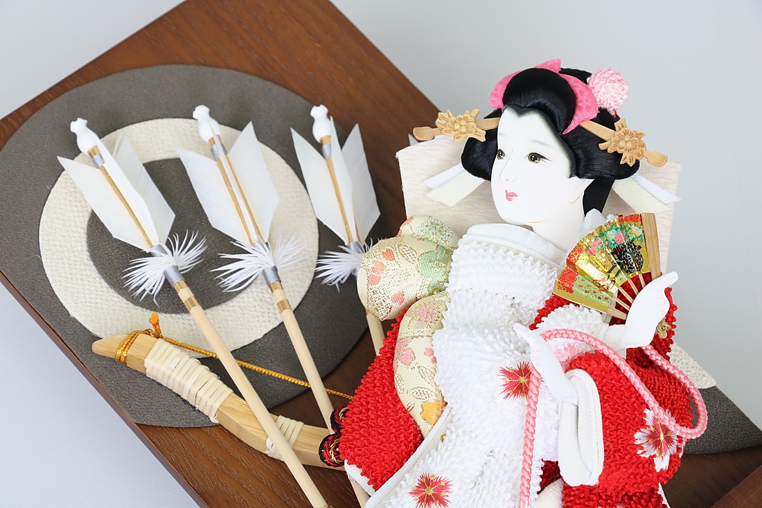 並べて飾った羽子板と破魔弓。振袖姿の羽子板と、白い矢羽根の破魔弓